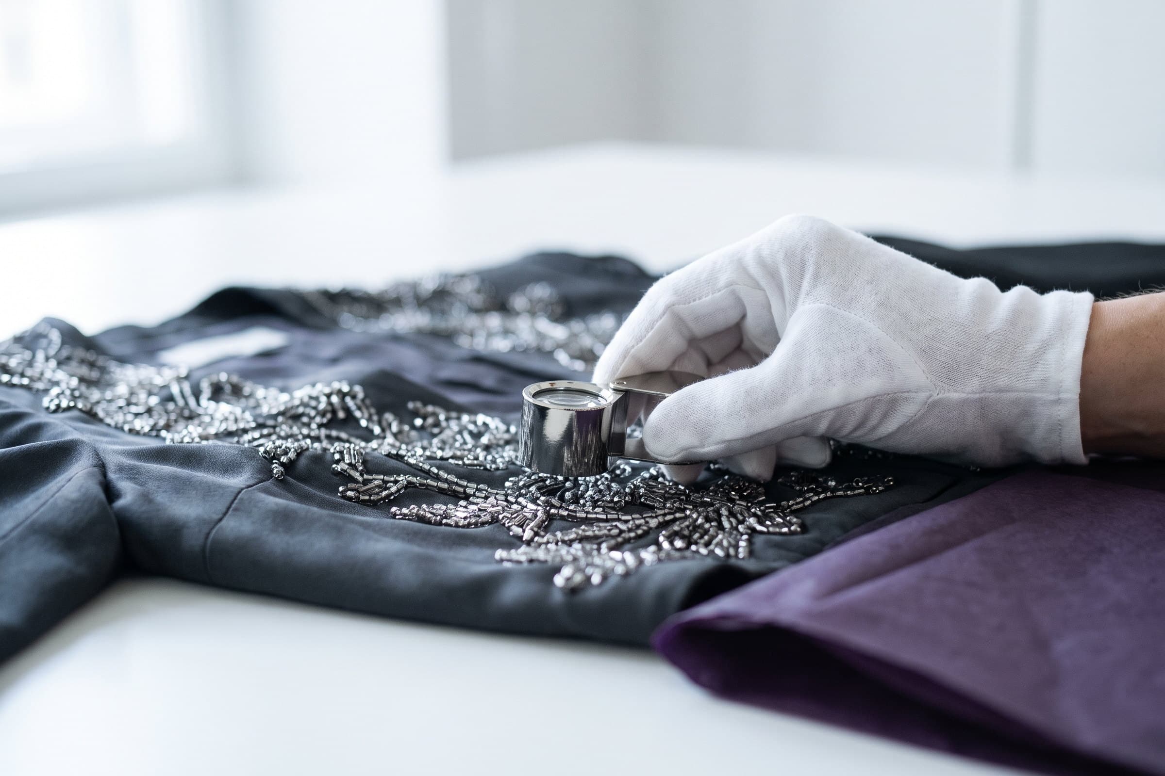 A specialist inspecting the construction of a designer garment.